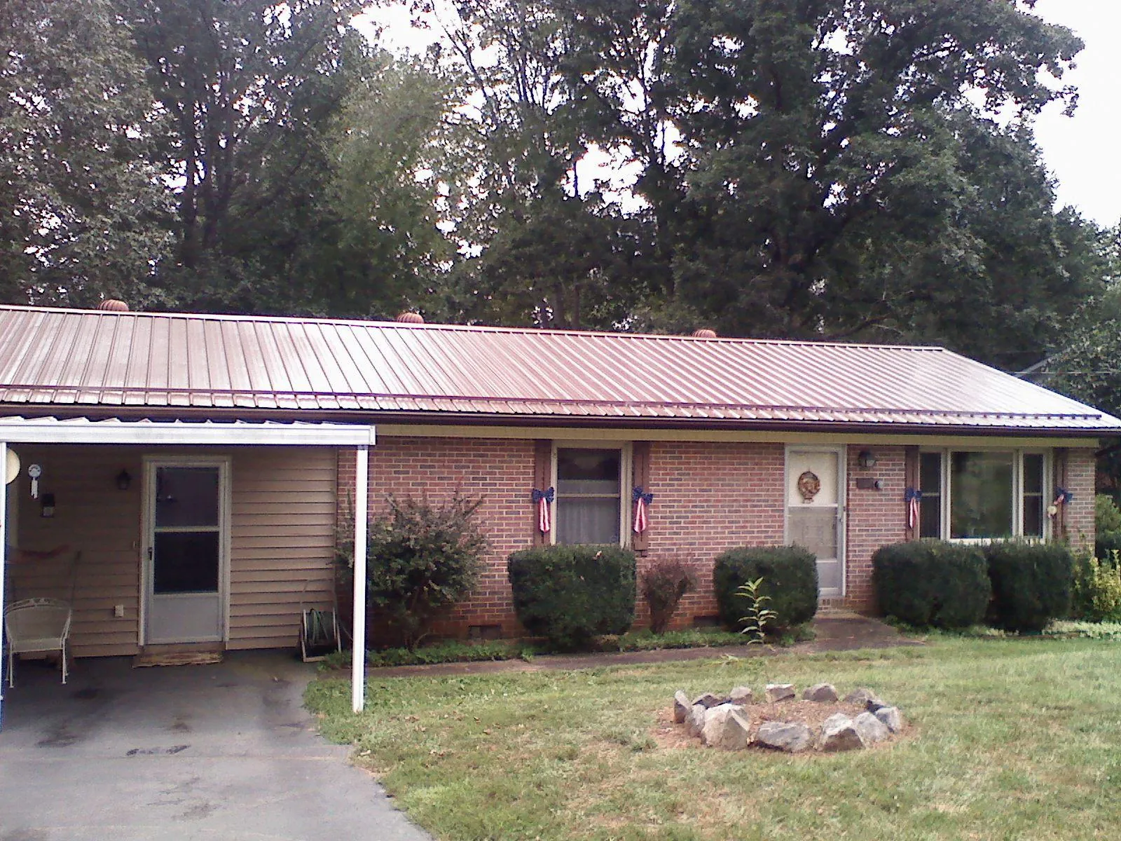Bronze metal roof and carport on a brick ranch home — Roof Repair work by our crew in Saratoga